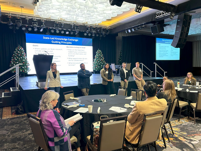 SGC staff at front of stage addressing attendees during a breakout session.