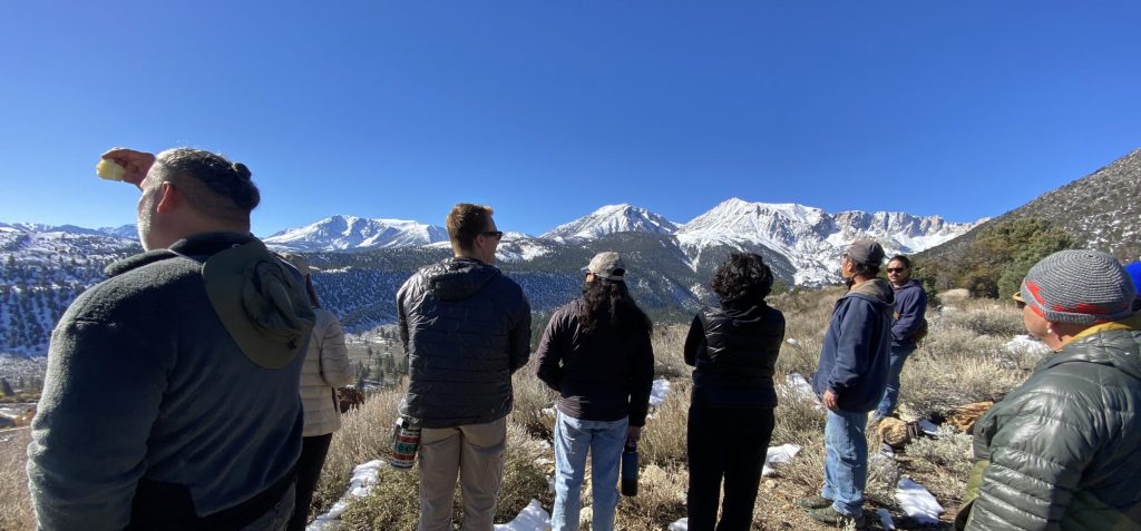 A group of people looking over a snow-covered mountain range