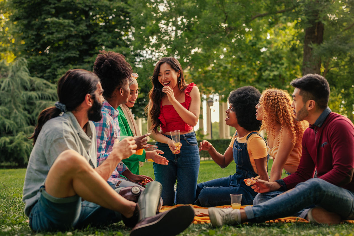 People at a picnic sitting on a blanket in the grass