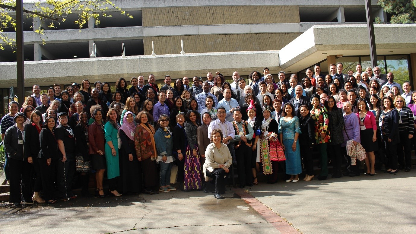 A large, diverse group of people pose for a photo.