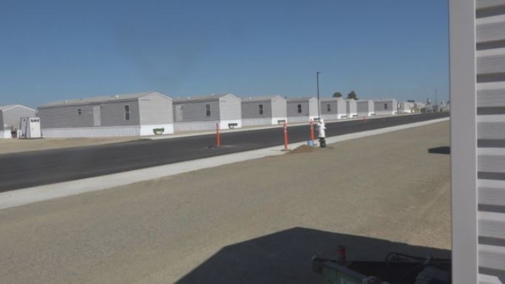 Multiple factory-built homes lining street. 